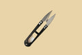 Two small pocket knives with black handles on a tan background