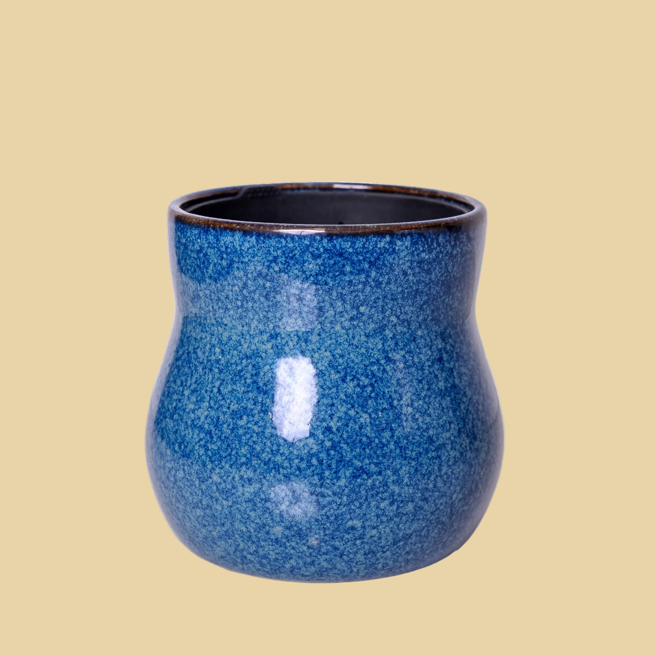 Blue ceramic cup with speckled texture on a white background