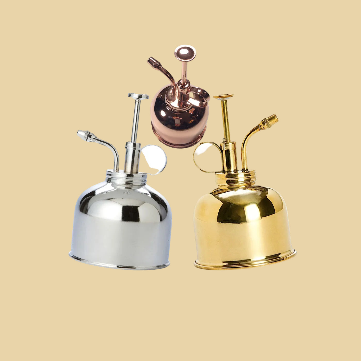 Three metallic water misters in silver, gold, and rose gold on a white background