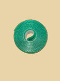 Roll of green velcro plant tape on a plain background